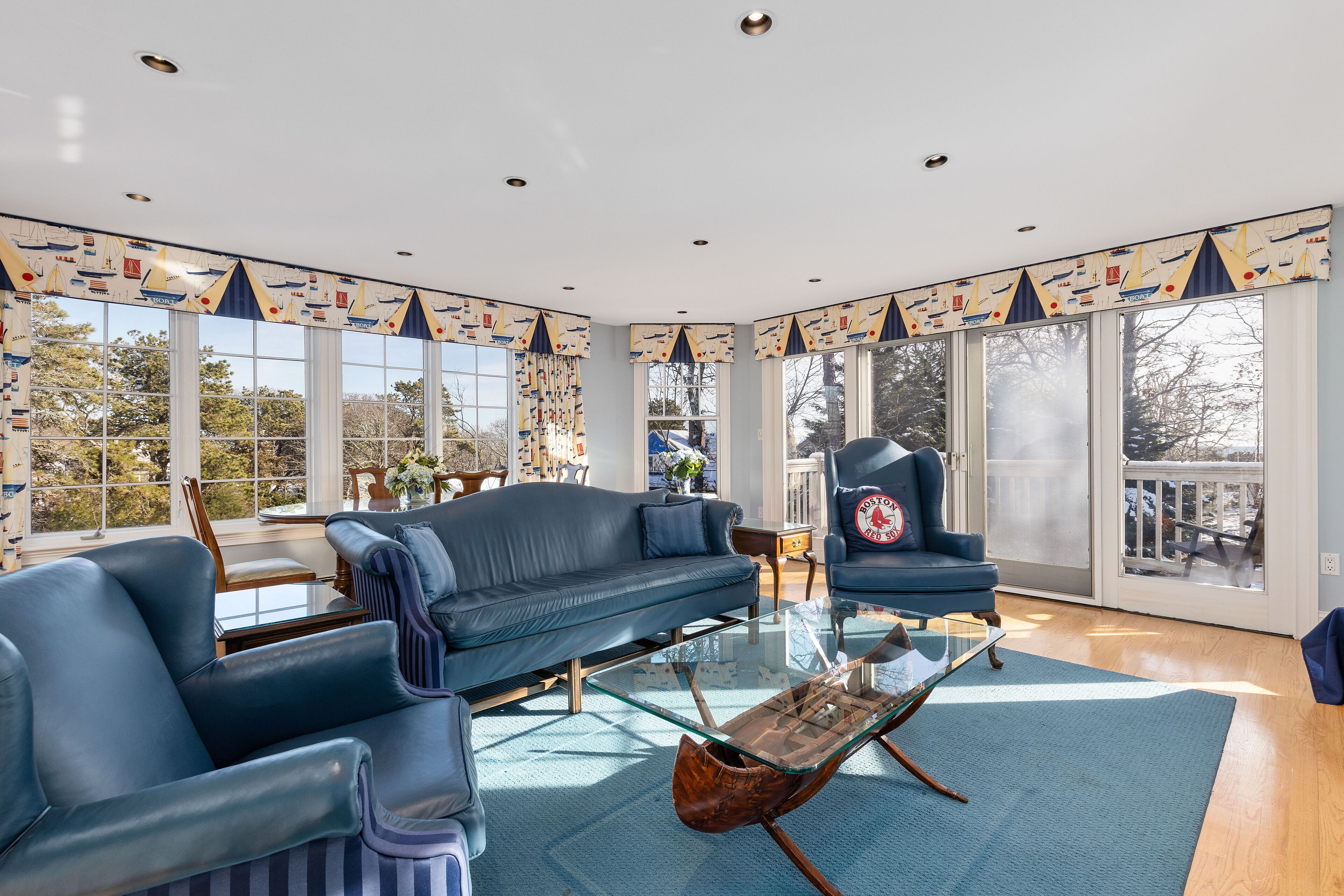Un salon spacieux avec un canapé bleu, une table basse en verre et un fauteuil bleu.