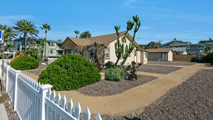 A residential area with houses, a white picket fence, and various plants. - Carlsbad Cottage by the Beach (Carlsbad)