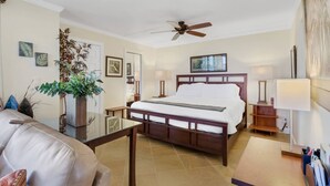 A hotel room with a bed, a ceiling fan, a large plant, and a view of the city. - 10TH FLOOR GULF & BEACH VIEWS | FREE WIFI | KING BED | FREE PARKING | BEACH GEAR (Bonita Springs)