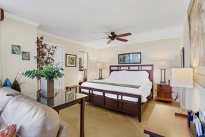 A hotel room with a bed, a ceiling fan, a large plant, and a view of the city. - 10TH FLOOR GULF & BEACH VIEWS | FREE WIFI | KING BED | FREE PARKING | BEACH GEAR (Bonita Springs)