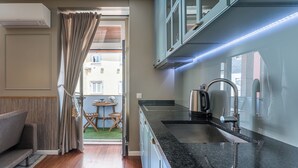 Eine moderne Küche mit Einbauherd, Spüle und einem Fenster mit Vorhängen.