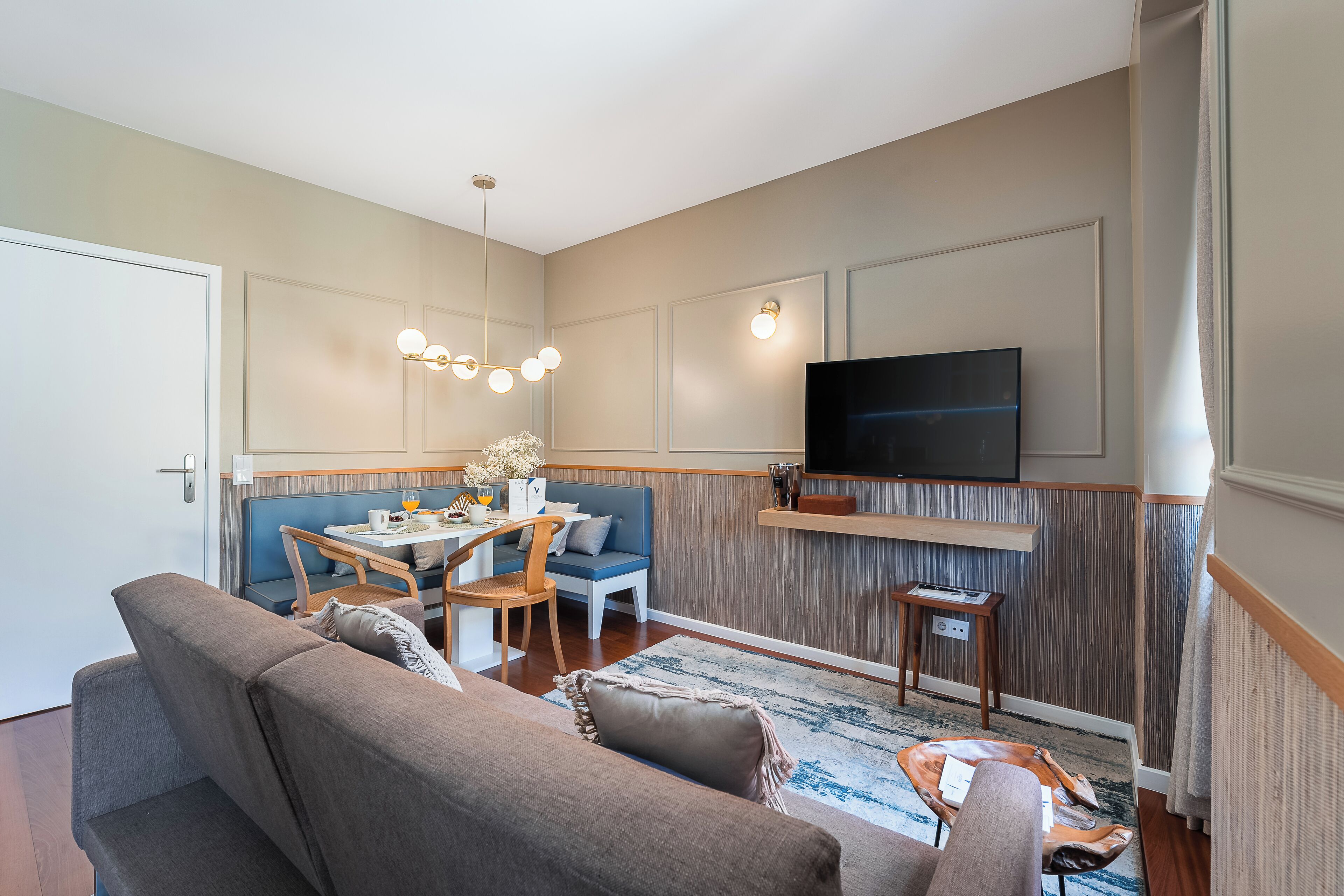 A modern living room with a sofa, dining table, and TV.