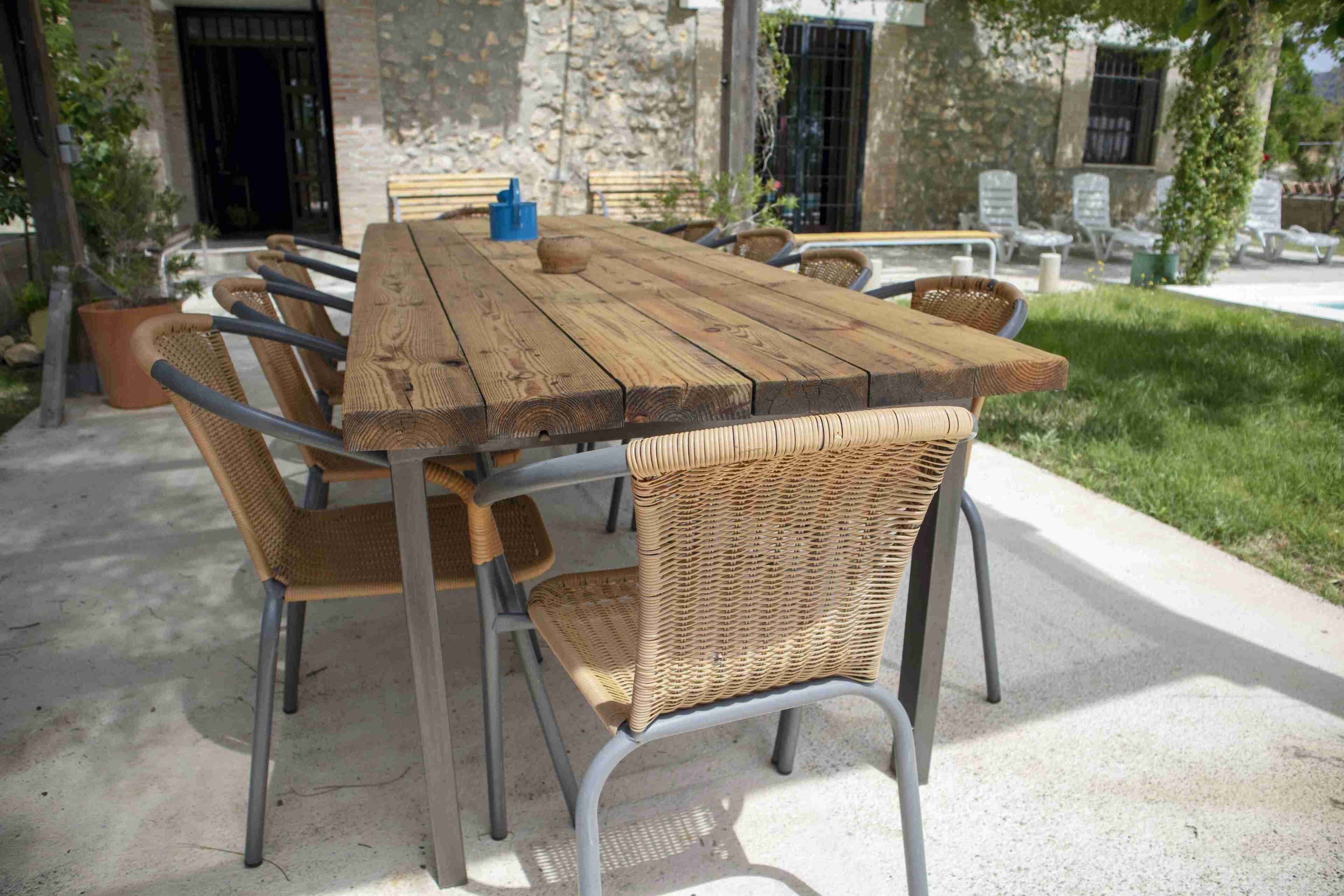 A wooden table with metal chairs in an outdoor patio area.
