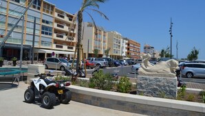 Un hotel sulla spiaggia con numerosi balconi, una spiaggia sabbiosa e una torre di salvataggio.