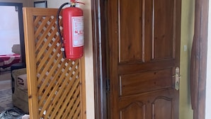 Eine Holztür mit einem an der Wand befindlichen Feuerlöscher in der Nähe.