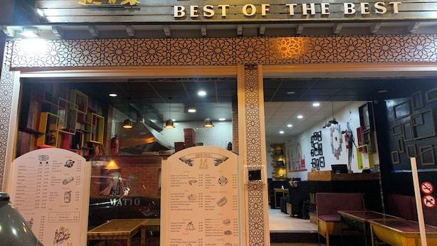 Der Eingang eines Restaurants namens 'Matto' mit einer Speisekarte und einem dekorativen Schild über dem Eingang.