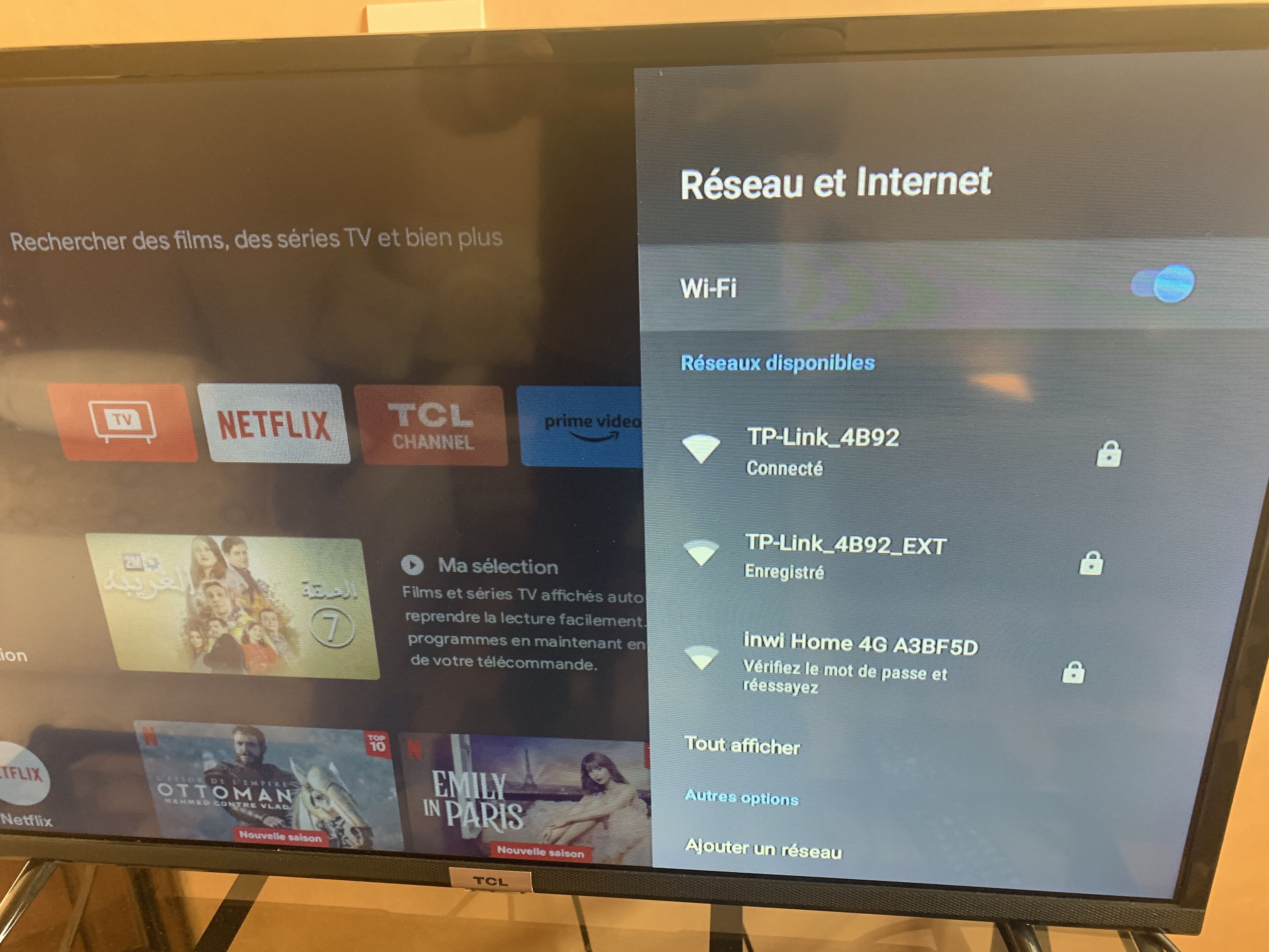 A television screen displaying a TV streaming interface with various streaming services and network options.