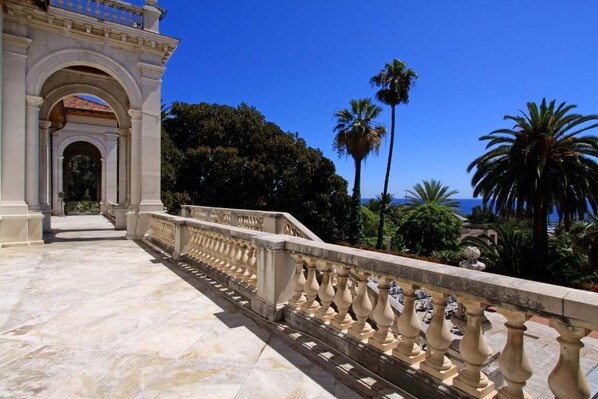 A marble pathway leading to a classical building with an arched entrance.