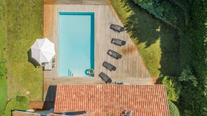 An aerial view of a rectangular swimming pool with a wooden deck, surrounded by greenery. - Profitez de votre piscine privée + accès golf (Moliets)