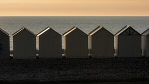 Une rangée de cabanes de plage avec vue sur la mer.