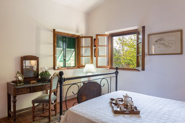 Une pièce comprenant un bureau, une chaise et une table sur laquelle se trouve un plateau avec des tasses et des théières.