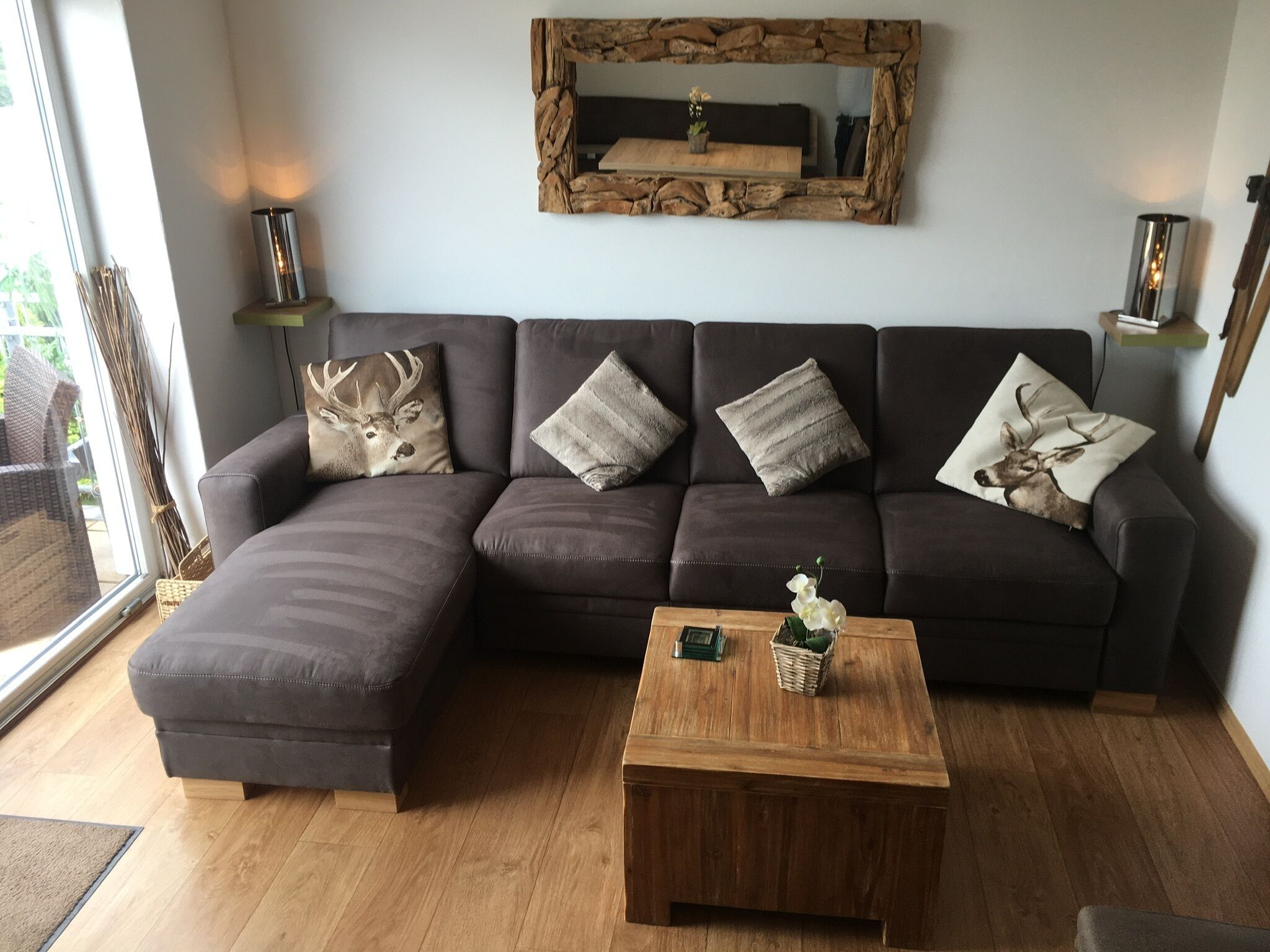 A modern living room with a sectional sofa, a wooden coffee table, and decorative pillows.