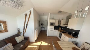A modern apartment with a living room, kitchen, and dining area.