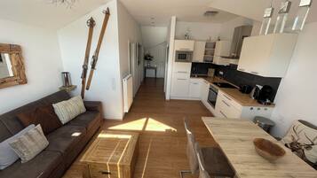 Eine moderne Wohnung mit Wohnzimmer, Küche und Essbereich.