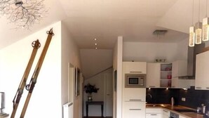 A modern apartment with a living room, kitchen, and dining area.