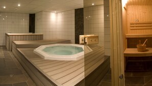 A spa area with a hot tub, wooden benches, and a sauna.