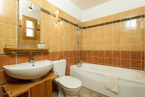 Une salle de bain avec un lavabo, des toilettes et une baignoire.