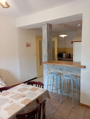 Enjoy meals in a cozy dining area with a table for two and a bar counter for casual seating.