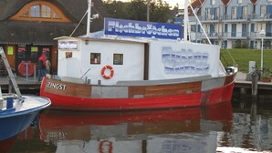 A red and white boat docked at a marina with a sign reading "Fischbrötchen". - Maisonette apartment 70m² with 2x shower / WC and 2 bedrooms Central WLAN (Zingst)