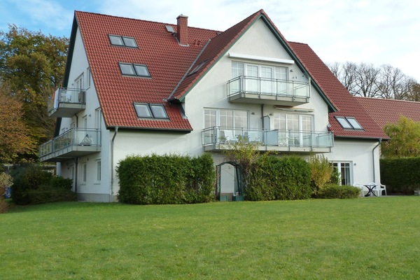 Ansicht des Appartmenthauses von hinten mit großer Spielwiese