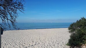 Une plage de sable blanc, sous un ciel bleu azur.
