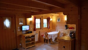 A cozy wooden cabin interior with a dining area, a television, and a coffee station. - 538 sq ft chalet for 4 persons in Saint Gervais Mont-Blanc (Saint-Gervais-Les-Bains)