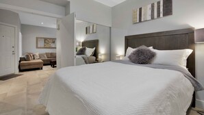 Un dormitorio moderno con una cama grande, un sofá y un espejo.