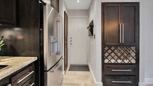 Una cocina moderna con armarios de madera oscura, electrodomésticos de acero inoxidable y encimera de mármol.