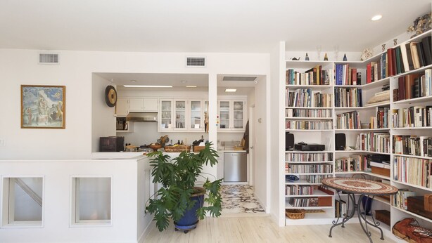 A spacious living area with a kitchen, a large bookshelf, and a dining table. - Beautiful apartment with balconies and views, near park and museums in Nolita (New York)