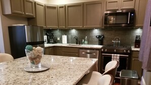 A modern kitchen with granite countertops, stainless steel appliances, and a central island with seating. -  Jones St Hist Dist Gem 1853- 3KgBd/3Ba exquisite courtyard- 50 %offSun -ThurNts (Savannah)