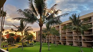 A multi-story hotel with balconies, palm trees, and a well-maintained lawn. - Maui Sunset B201: Beautiful 2 Bedroom, 2 Bath, Kihei Condo. Sleeps up to Six (Kihei)