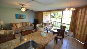 A kitchen with a granite countertop, a sink, and a dining area with chairs and a table. - Maui Sunset B201: Beautiful 2 Bedroom, 2 Bath, Kihei Condo. Sleeps up to Six (Kihei)