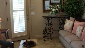 A living room with a sofa, a coffee table, a dining table, and a kitchen area with cabinets and a microwave. - Biltmore Golf and Resort (just steps away from the fabulous Biltmore Hotel) (Phoenix)