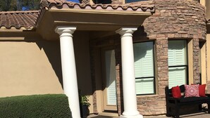 A house with a stone facade, a covered porch with white columns, and a black outdoor seating area with red cushions. - Biltmore Golf and Resort (just steps away from the fabulous Biltmore Hotel) (Phoenix)