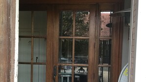 A wooden door with a glass panel, a doormat with "hello" written on it, and a tiled floor. - Charming 2 bedroom condo in the heart of beautiful Natchez, MS. (Natchez)