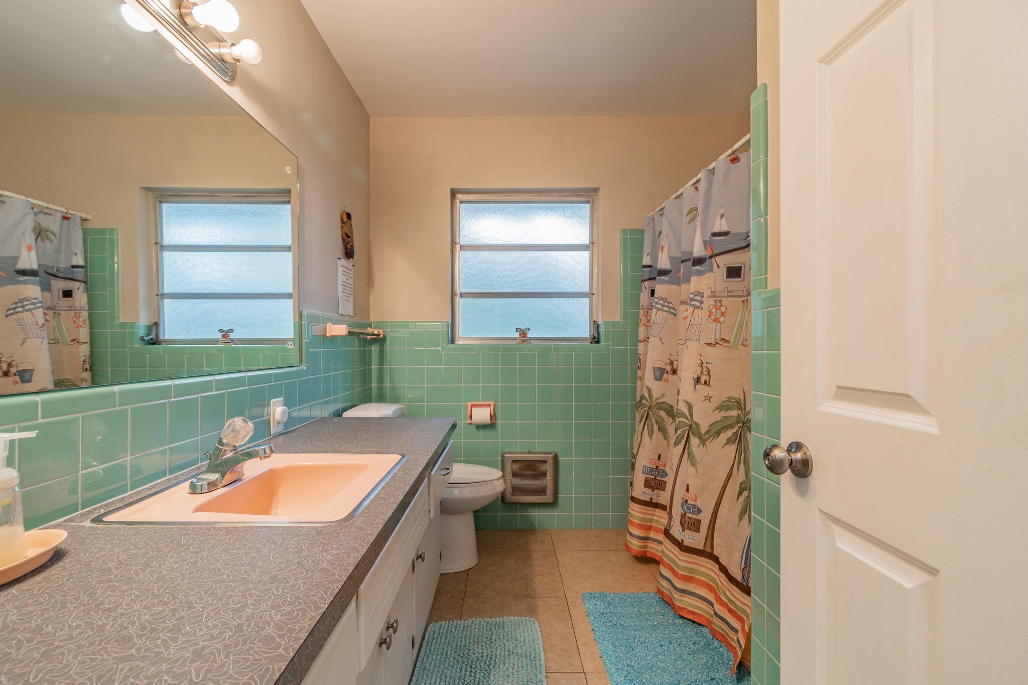 Een badkamer met een wastafel, toilet en raam.