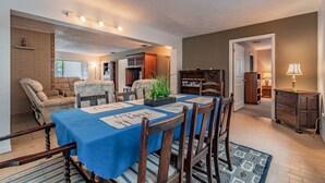 A dining area with a blue tablecloth, wooden chairs, and a plant centerpiece. - Siesta beach....one and only (Sarasota)