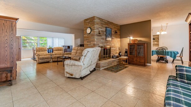 A spacious living room with a stone fireplace, comfortable seating, and a view of the outdoors. - Siesta beach....one and only (Sarasota)