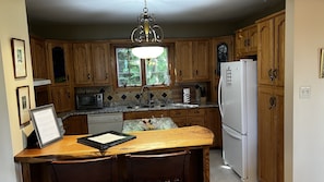 Kitchen features a central island with sink, refrigerator, and microwave.