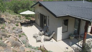 Una casa con patio, mobiliario exterior y vistas del paisaje circundante.