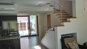 Una cocina moderna con refrigerador incorporado y una zona de comedor con sofá y mesa de centro.