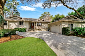 A two-story house with a front porch, a garage, and a well-maintained lawn.