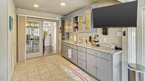 A kitchen with grey cabinets, a granite countertop, and a black range hood. - Waterfront View Perfect for Fun Loving Families!  (Hilton Head Island)