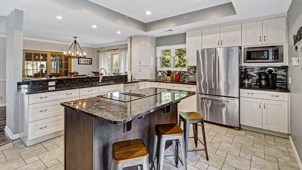 A modern kitchen with a central island, stainless steel appliances, and white cabinetry. - Waterfront View Perfect for Fun Loving Families!  (Hilton Head Island)