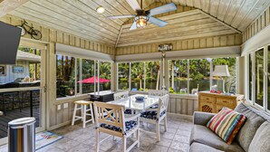 A covered patio with a dining table, chairs, and a sofa. - Waterfront View Perfect for Fun Loving Families!  (Hilton Head Island)