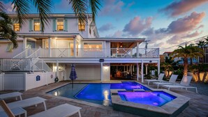 A two-story house with a swimming pool and outdoor seating. - Dragonfly - Southern charm on the North end of Anna Maria Island (Anna Maria)