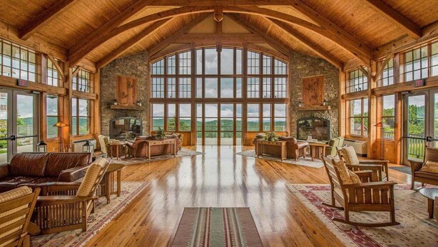 A spacious room with a high ceiling, large windows, and a fireplace. - Soaring Eagle #406:  2 Bedrooms, 2 Full Baths:  Slope Side,  Hot Tubs. Underground Parking. (Snowshoe)