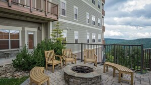A multi-story building with a fire pit and outdoor seating area. - Soaring Eagle #406:  2 Bedrooms, 2 Full Baths:  Slope Side,  Hot Tubs. Underground Parking. (Snowshoe)
