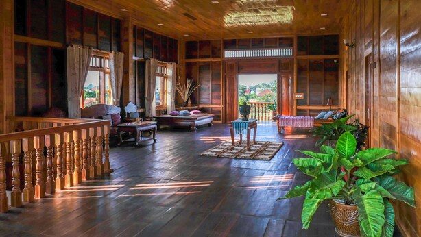 A spacious wooden interior with a balcony, seating area, and large windows. - Heart of Wonder Villa (Siem Reap)