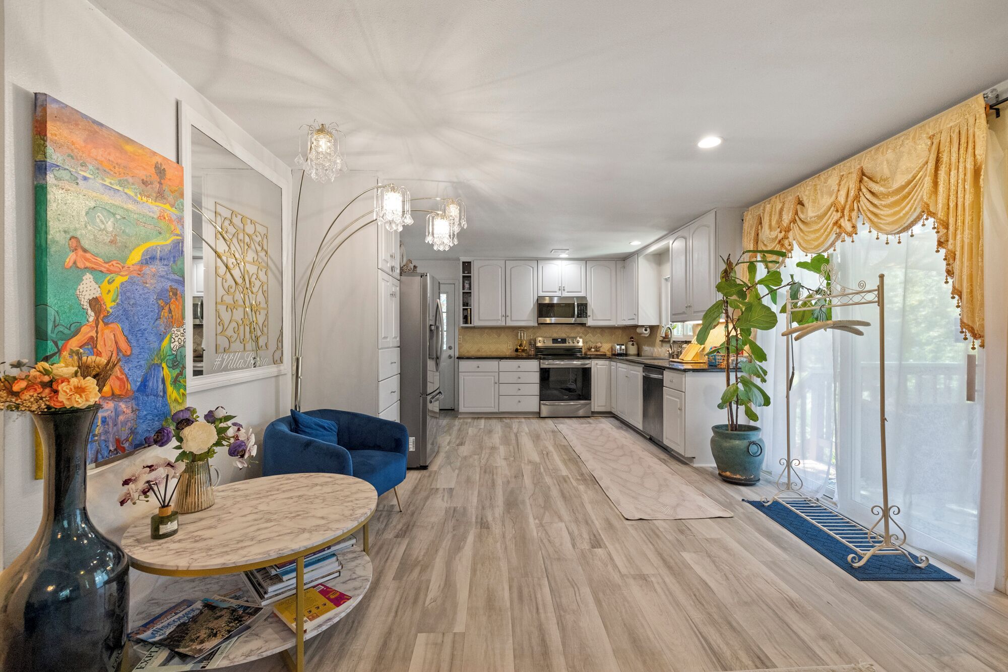 A modern kitchen with white cabinets, stainless steel appliances, and a central island.